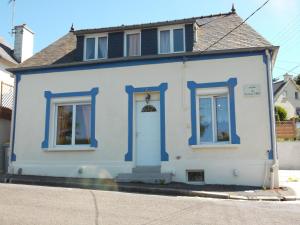 Les Gîtes Bleus de Lannion - avec cuisine- في لانيون: منزل أبيض مع تقليم أزرق على شارع