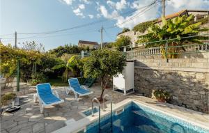 eine Terrasse mit 2 Stühlen und einem Pool in der Unterkunft Amazing Apartment In Herceg Novi With Kitchen in Herceg-Novi