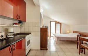 eine Küche mit einem Bett im Hintergrund und eine Küche mit einer Küche in der Unterkunft Amazing Apartment In Herceg Novi With Kitchen in Herceg-Novi