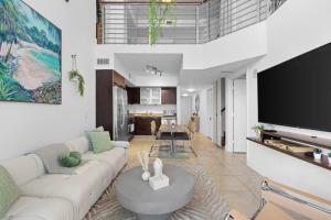 a living room with a white couch and a tv at Stylish 3 bed/2 bath 2 story in Miami