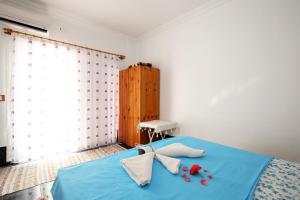 a bedroom with a blue bed with red roses on it at Rose Hotel B&B in Patara