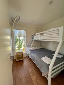 a bedroom with a bunk bed and a window at Shelly Beach Holiday Park in The Entrance