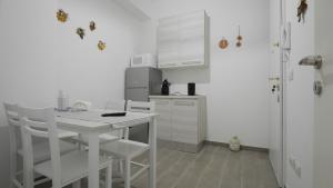 een witte keuken met een witte tafel en stoelen bij Il Centro Apartments in Bari