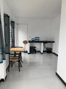a white room with a table and chairs on a white floor at Home Daun Kam in Kampot