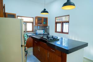 uma cozinha com um balcão preto e um frigorífico em Villa Green Space em Matara