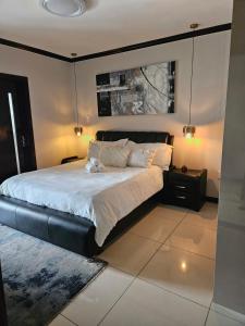 Schlafzimmer mit einem großen Bett mit einem schwarzen Kopfteil in der Unterkunft Candymoore apartment in Sandton