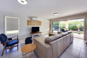 a living room with a large couch and a tv at Geckos at South West Rocks - 29 Marlin Drive in South West Rocks