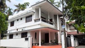 a white building with a balcony on a street at Hosted by Resmi Jayalal in Cochin