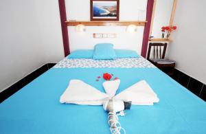 a bed with white towels and a flower on it at Rose Hotel B&B in Patara