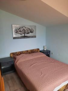 um quarto com uma cama e uma árvore na parede em Apartments Visnja - 10 meters to the sandy beach em Nin