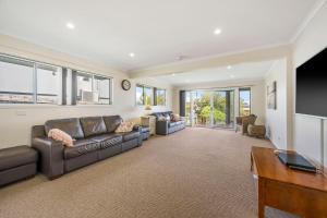 a living room with a leather couch and a tv at Topviews 15 Second Av BH in Bonny Hills