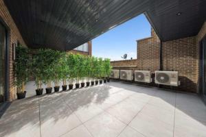 a courtyard with a row of potted plants on a building at OYO Fine B&B in Hanwell