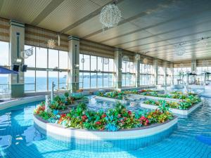 a swimming pool with flowers in a building at Mikazuki Sea-Park Hotel Katsuura in Katsuura