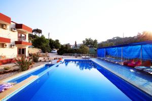 a large blue swimming pool next to a building at Rose Hotel B&B in Patara