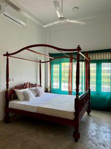 ein Schlafzimmer mit einem Bett mit einem Holzrahmen in der Unterkunft One Bhakthi in Ahangama