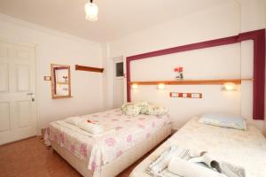 a bedroom with two beds and a window at Rose Hotel B&B in Patara