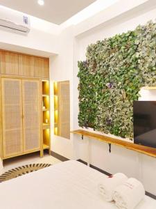um quarto com uma parede verde e uma televisão em Nagoya 名古屋 at Benson Apartment em Surabaya