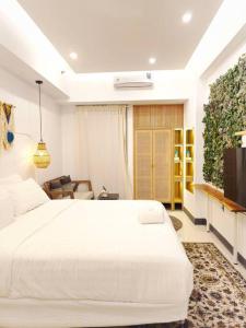 um quarto com uma grande cama branca e um sofá em Nagoya 名古屋 at Benson Apartment em Surabaya