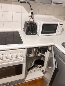a kitchen with an open oven and a microwave at Vaasa homestay in Vaasa
