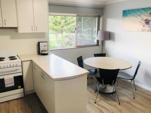 a small kitchen with a table and a table and chairs at API Middleton Beach Front Apartments Albany in Albany
