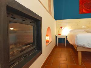 1 dormitorio con chimenea y cama. en Le camere dell'Albero Bianco con uso cucina, en Manzano