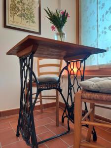 una mesa de madera con una silla debajo en Le camere dell'Albero Bianco con uso cucina, en Manzano