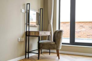 a chair sitting next to a desk and a mirror at OYO Fine B&B in Hanwell