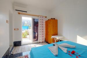 a bedroom with a blue bed and a large window at Rose Hotel B&B in Patara
