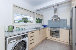 a kitchen with a washing machine and a window at 2 Bedroom Home away from Home near CBD & private parking in Hamilton