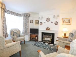 a living room with a fireplace and a tv at Bro Dawel in Beaumaris