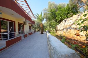a walkway next to a building with a stone wall at Rose Hotel B&B in Patara