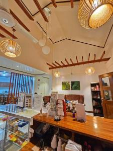 a restaurant with a counter with chairs and lights at Bella Vita Guest House in Coron