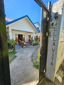 Una porta con il Wordarma scritto sopra davanti a una casa di Bella Vita Guest House a Coron