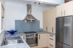a kitchen with a stainless steel refrigerator and a sink at 2 Bedroom Home away from Home near CBD & private parking in Hamilton