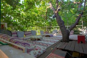 a couch sitting on a deck next to a tree at Rose Hotel B&B in Patara