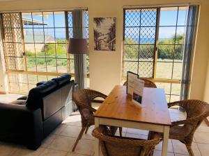 a living room with a table and chairs and a couch at API Preston Beach Front Apartments in Preston Beach