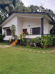 uma casa com um relvado em frente em Atharva Holiday Homes em Anjuna