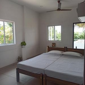 een slaapkamer met een bed en 2 ramen bij Bethesda Inn in Cochin