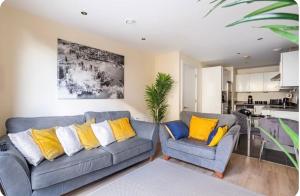 ein Wohnzimmer mit 2 Sofas und einer Küche in der Unterkunft Luxury Central London Apartment in London