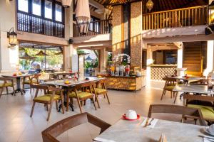 a dining room with tables and chairs and a restaurant at Puri Raja Hotel in Legian