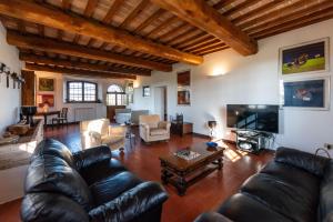 Villa Cucule في سيينا: غرفة معيشة مع أريكة جلدية وتلفزيون