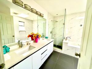 a white bathroom with a sink and a shower at Vancouver Bed & Breakfast in Richmond