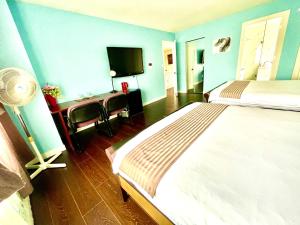 里士滿的住宿－Vancouver Bed & Breakfast，一间卧室配有一张床和一张书桌及电视