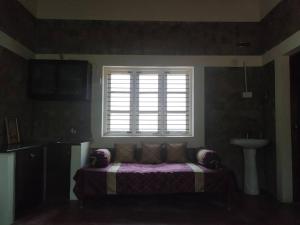 um quarto com uma cama, uma janela e um lavatório em VANIKA PLANTATION em Kikkeri