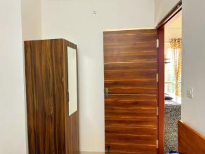 eine Holztür in einem Zimmer mit Spiegel in der Unterkunft Compact yet beautiful 1bhk 201 in Bangalore