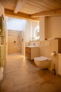 a bathroom with a toilet and a sink and a tub at Ferienwohnungen zum Nigglhof in Wackersberg