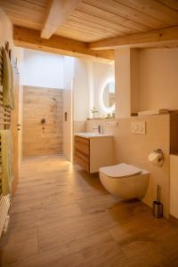 ein Badezimmer mit einem WC, einem Waschbecken und einer Badewanne in der Unterkunft Ferienwohnungen zum Nigglhof in Wackersberg
