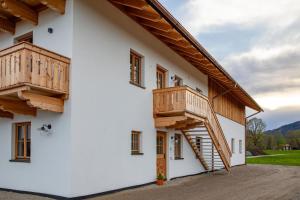 ein Haus mit Holzbalkonen an der Seite in der Unterkunft Ferienwohnungen zum Nigglhof in Wackersberg