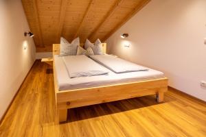 ein Schlafzimmer mit einem großen Bett im Dachgeschoss in der Unterkunft Ferienwohnungen zum Nigglhof in Wackersberg