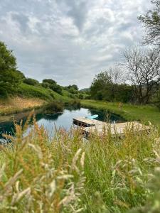 a river with a boat in the middle of it at Bracken Yurt at Walnut Farm Glamping in Netherbury